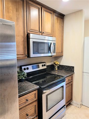 a kitchen with granite countertop cabinets stainless steel appliances and a window