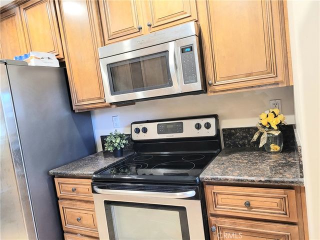 a kitchen with stainless steel appliances granite countertop a stove and a microwave