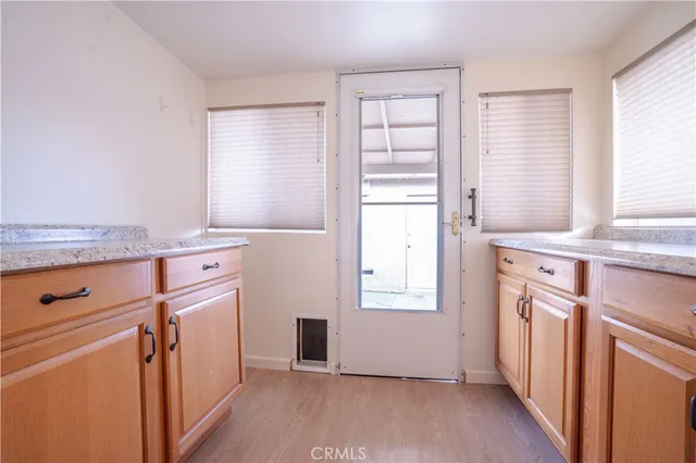 an entryway with wooden floor and cabinet