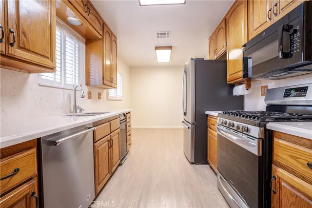 a kitchen with stainless steel appliances granite countertop a stove a sink and a refrigerator