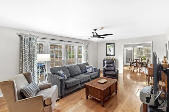 a living room with fireplace furniture and a large window