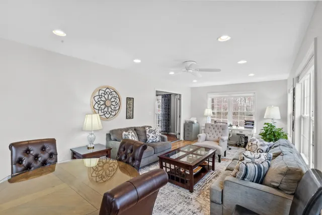 a kitchen with stainless steel appliances granite countertop a refrigerator a sink a stove a dining table and chairs