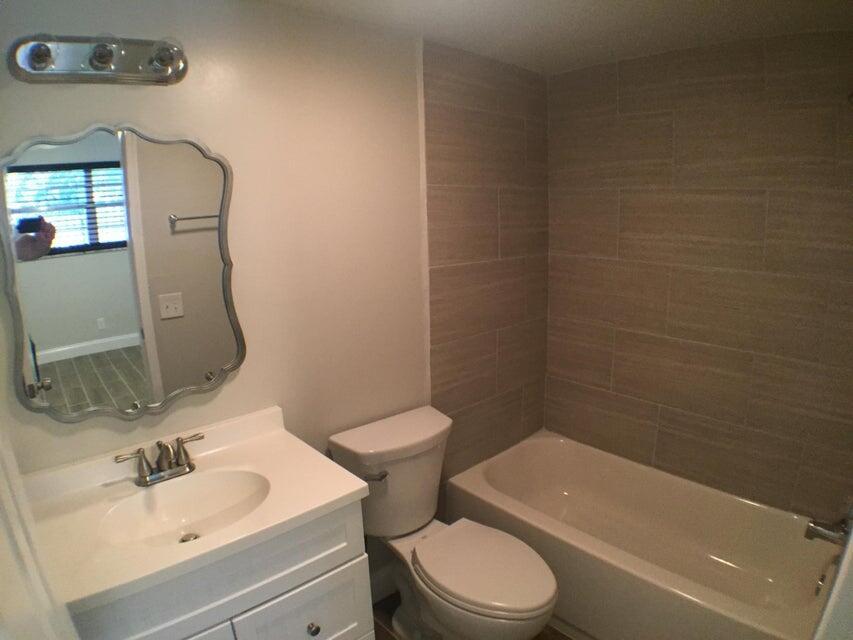 660 Glouchester Street, Unit 105 Boca Raton, FL 33487 - Photo 11 of 13 a bathroom with a sink a toilet and shower