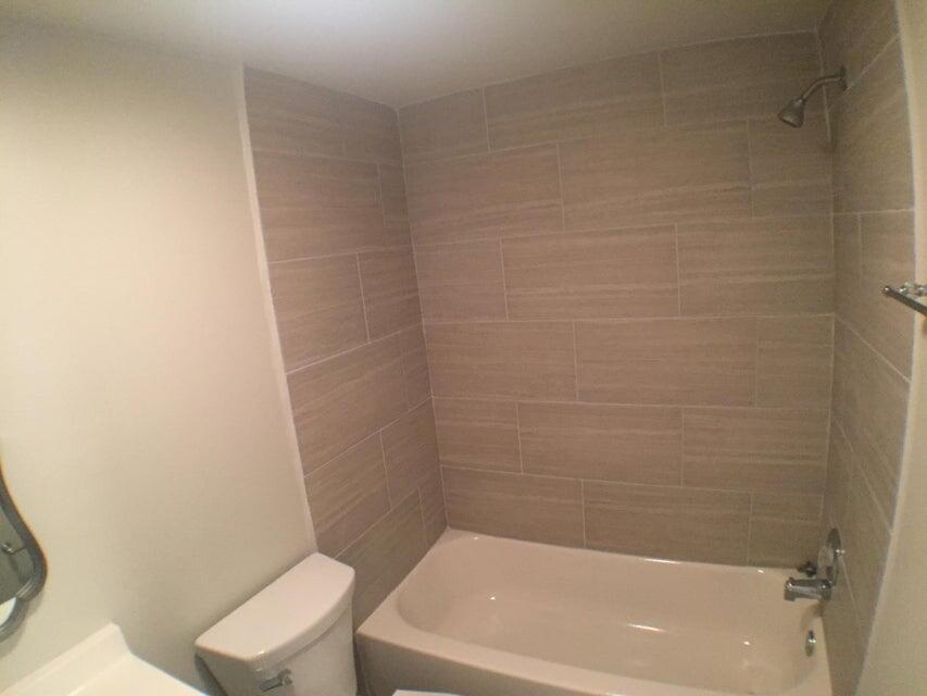 660 Glouchester Street, Unit 105 Boca Raton, FL 33487 - Photo 12 of 13 a bath tub sitting next to a white toilet