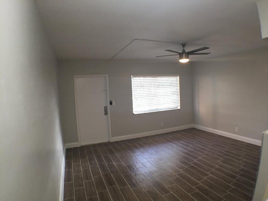 660 Glouchester Street, Unit 105 Boca Raton, FL 33487 - Photo 4 of 13 an empty room with wooden floor fan and windows