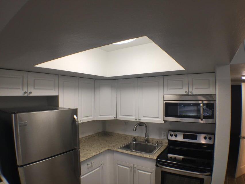 660 Glouchester Street, Unit 105 Boca Raton, FL 33487 - Photo 6 of 13 a kitchen with stainless steel appliances a refrigerator and a stove top oven