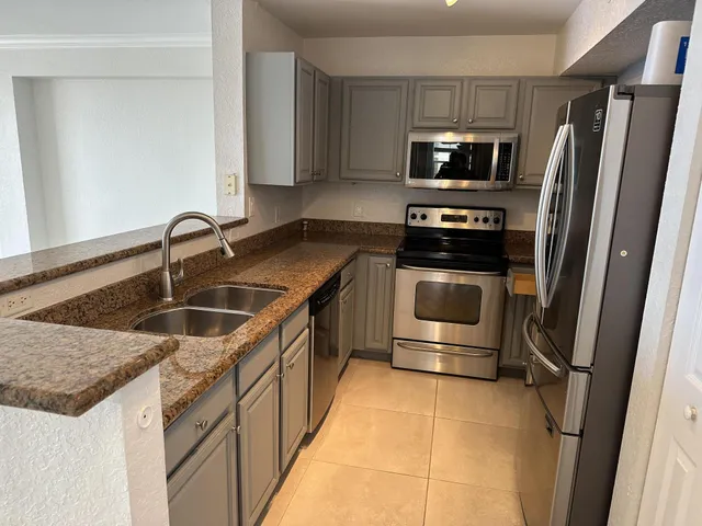 a kitchen with a sink a stove and stainless steel appliances