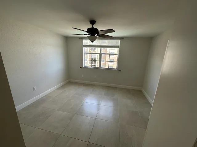 en empty room with windows and ceiling fan
