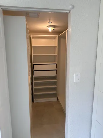 a view of walk in closet with empty racks