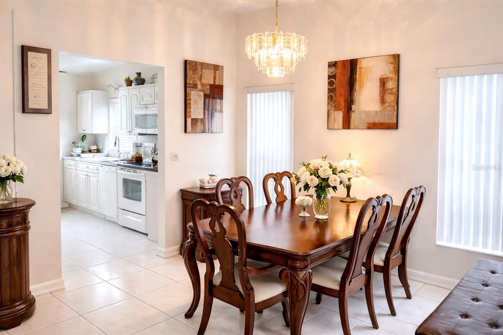 3637 Downfield Place, Unit 402 New Port Richey, FL 34655 - Photo 7 of 39 a view of a dining room with furniture and chandelier