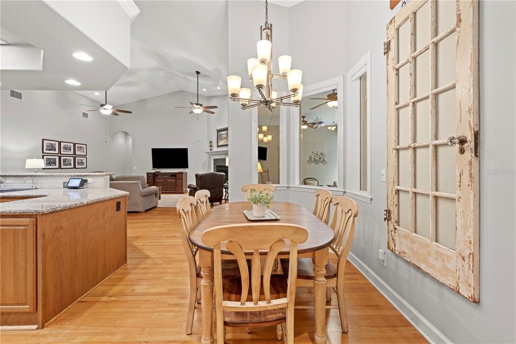 23245 Croom Road Brooksville, FL 34601 - Photo 21 of 79 a view of a dining room with furniture a chandelier and wooden floor
