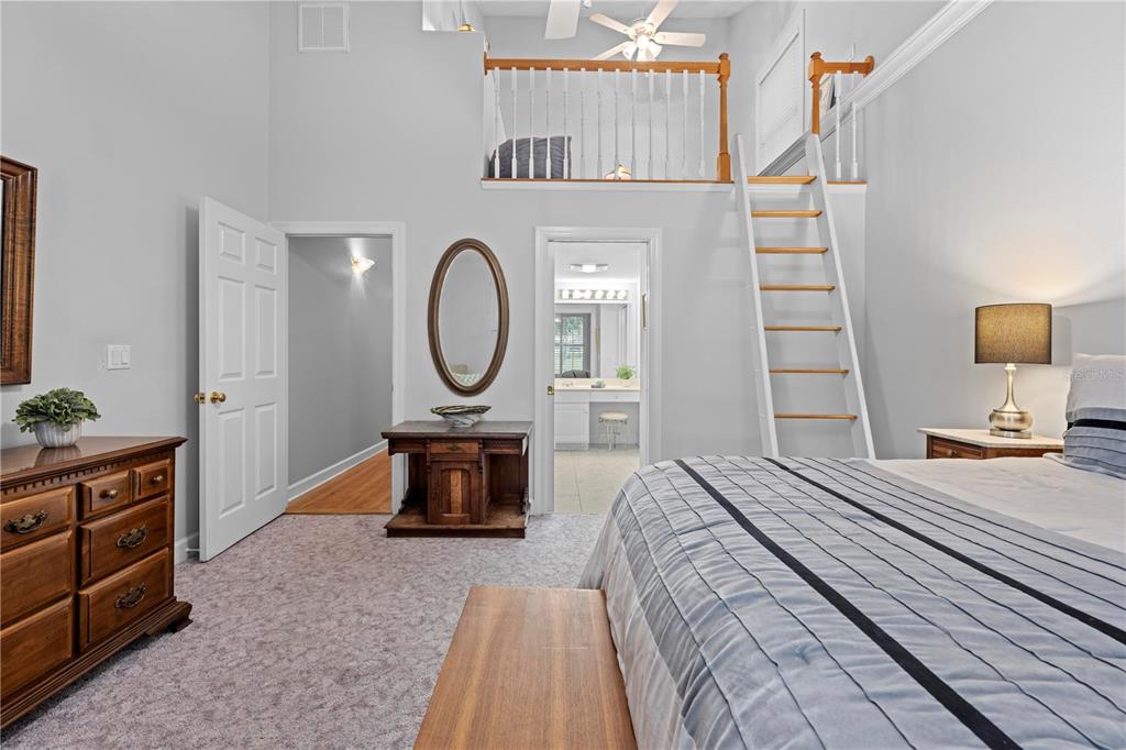 23245 Croom Road Brooksville, FL 34601 - Photo 44 of 79 a bedroom with a bed a mirror on dresser and a chandelier