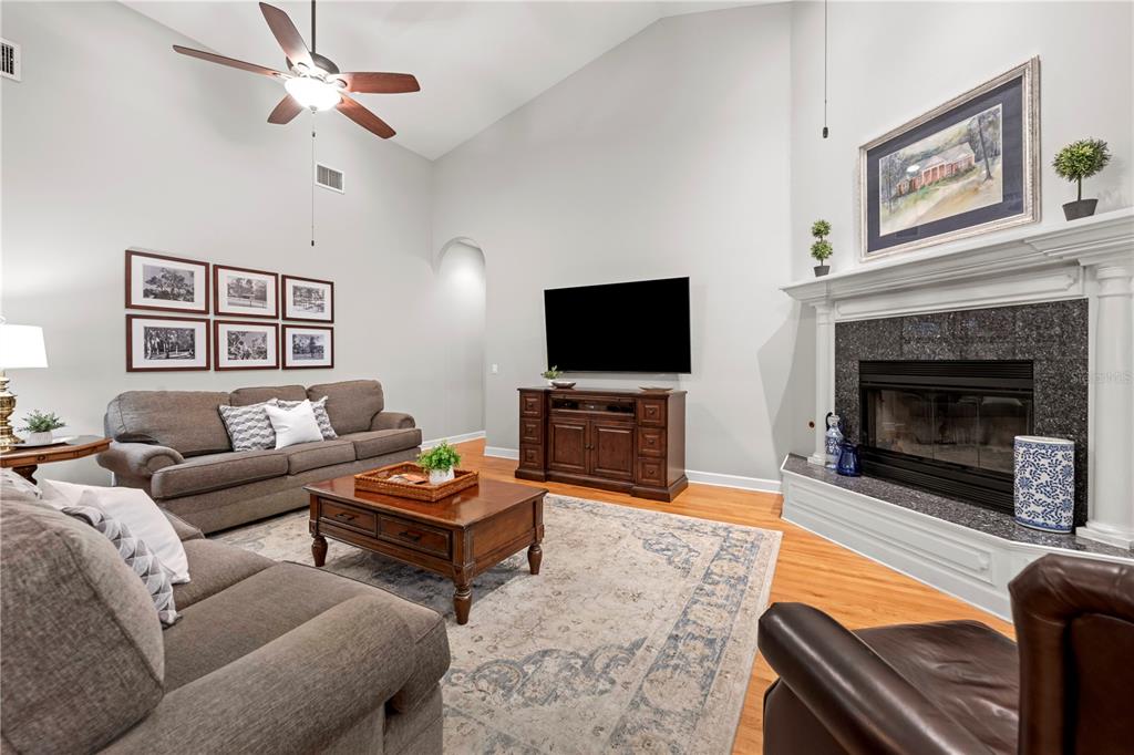 23245 Croom Road Brooksville, FL 34601 - Photo 10 of 79 a living room with furniture a flat screen tv and a fireplace