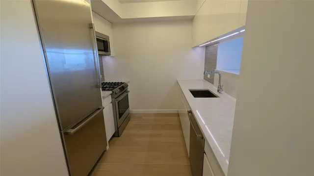 a bathroom with a sink a refrigerator a washer and dryer