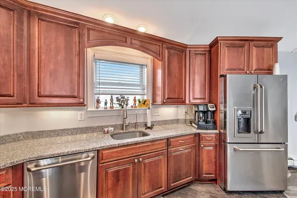 a kitchen with stainless steel appliances granite countertop a refrigerator and a sink