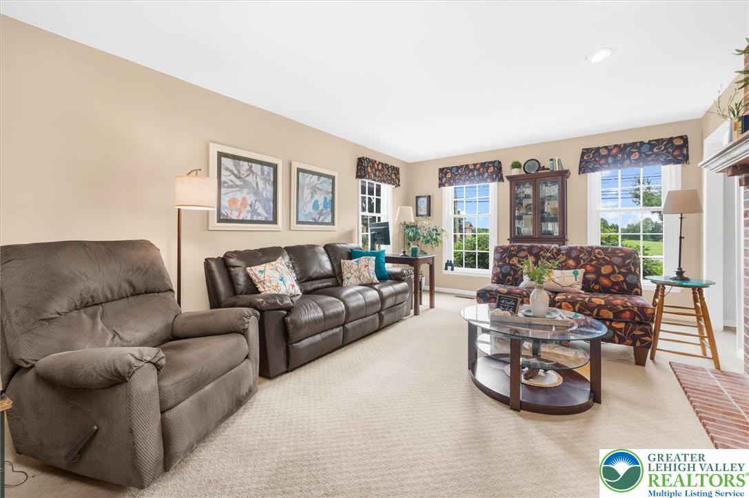 5616 Snowdrift Road Orefield, PA 18069 - Photo 13 of 36 Relax in a generously sized living room, featuring soft carpeting and a brick-detailed fireplace.