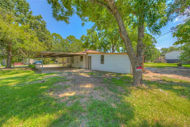 a view of a green field with trees in the background
