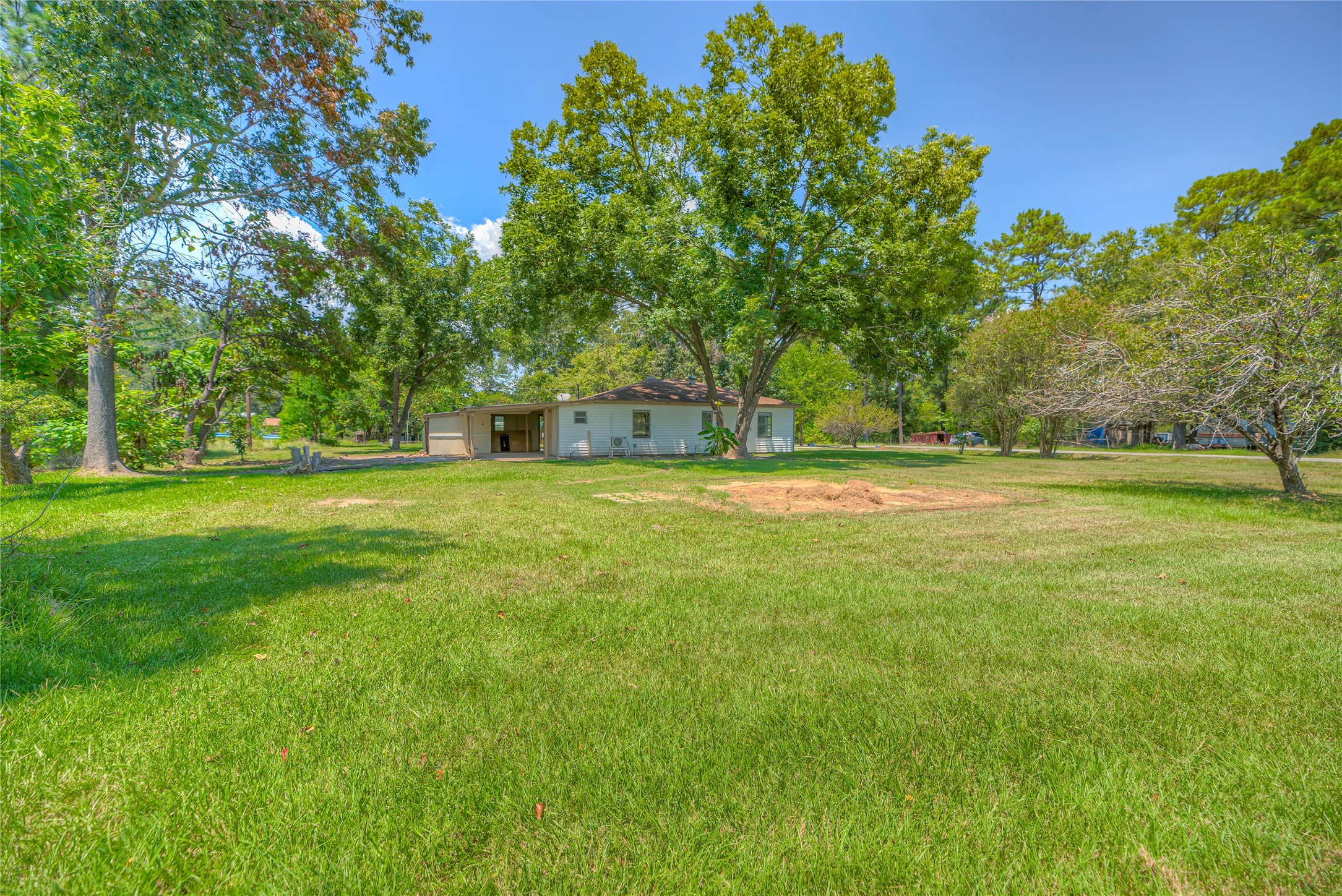 305 Oak Ridge Drive Onalaska, TX 77360 - Photo 23 of 29 a view of a green field with trees in the background