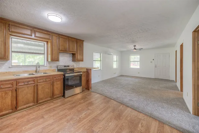 a large kitchen with granite countertop a stove a sink and a refrigerator