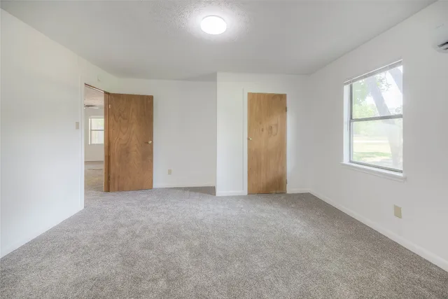 an empty room with windows and closet