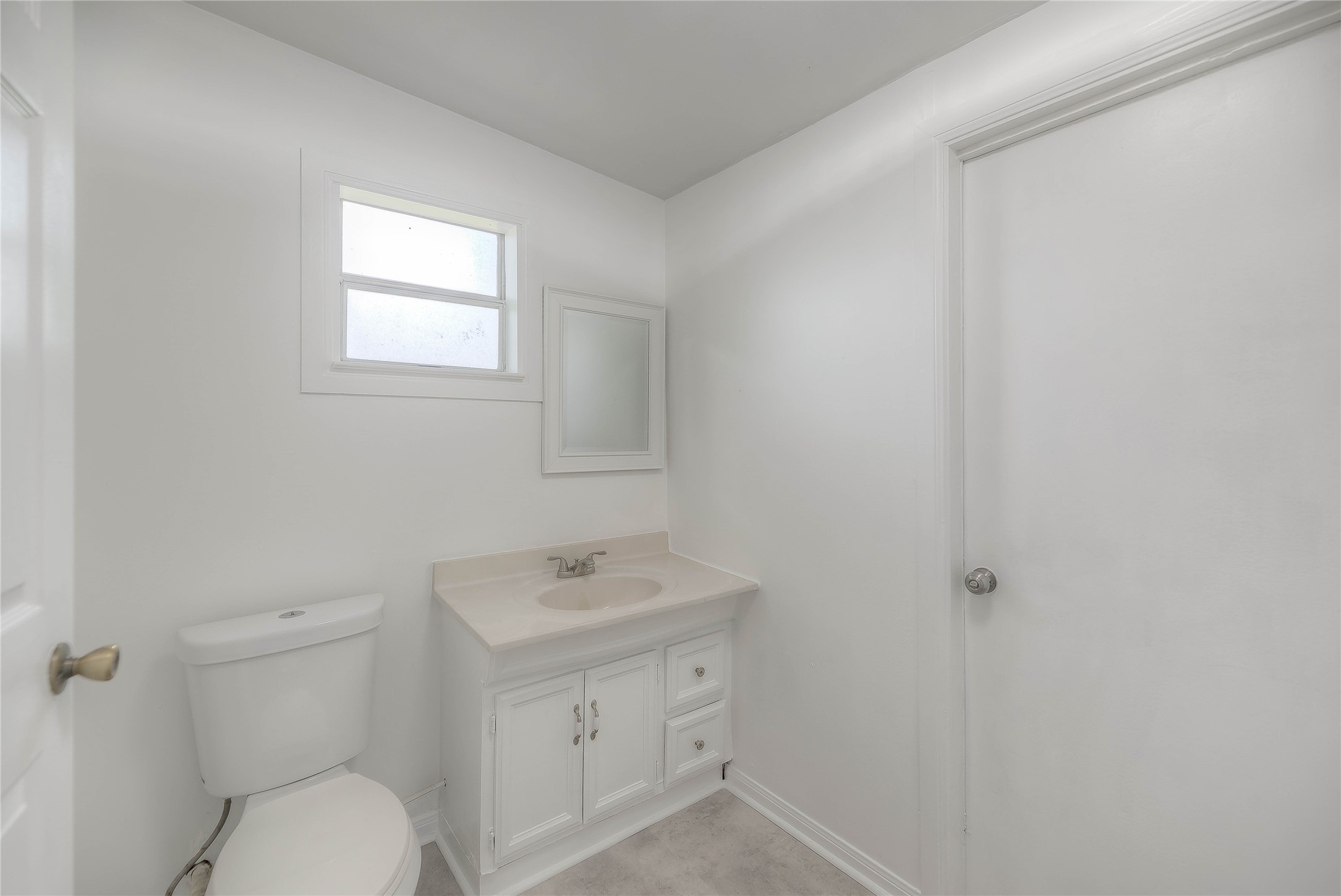 305 Oak Ridge Drive Onalaska, TX 77360 - Photo 8 of 29 a bathroom with a toilet a sink a mirror and a window