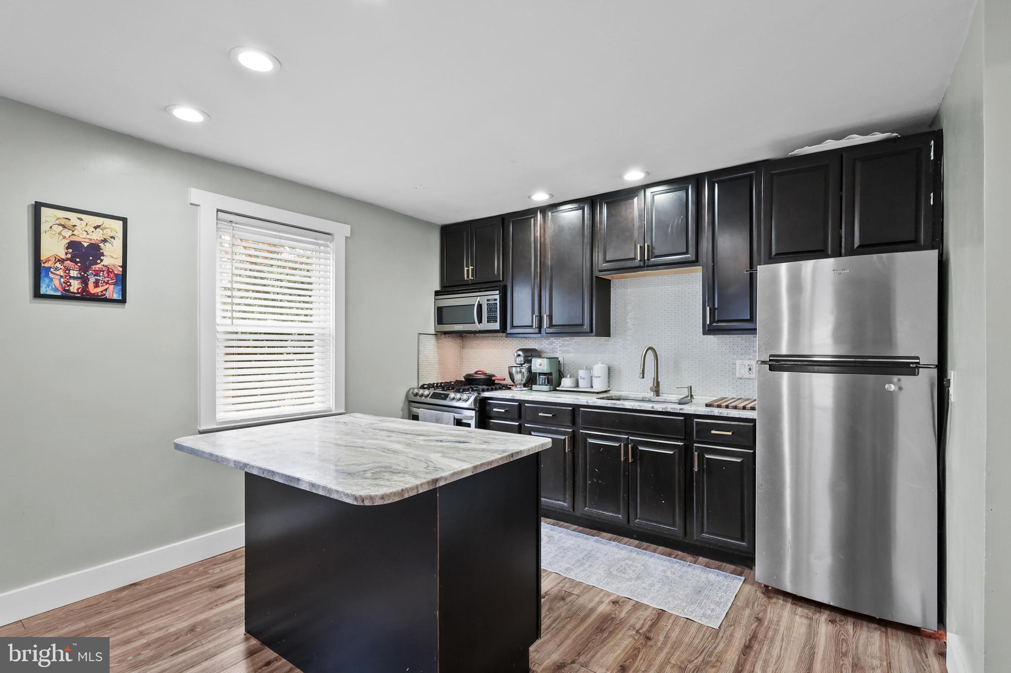 1020 Dartmouth Road Baltimore, MD 21212 - Photo 12 of 46 a kitchen with kitchen island granite countertop a sink stove and refrigerator