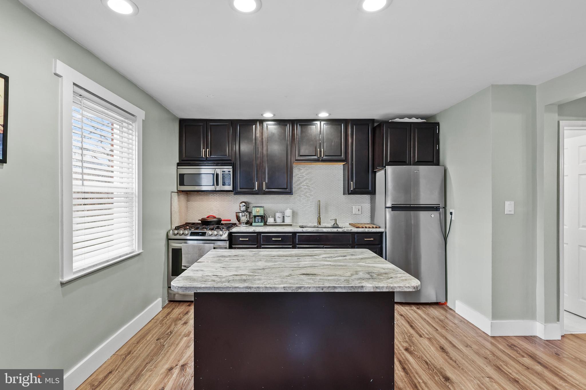 1020 Dartmouth Road Baltimore, MD 21212 - Photo 14 of 46 a kitchen with kitchen island granite countertop a sink stove and refrigerator