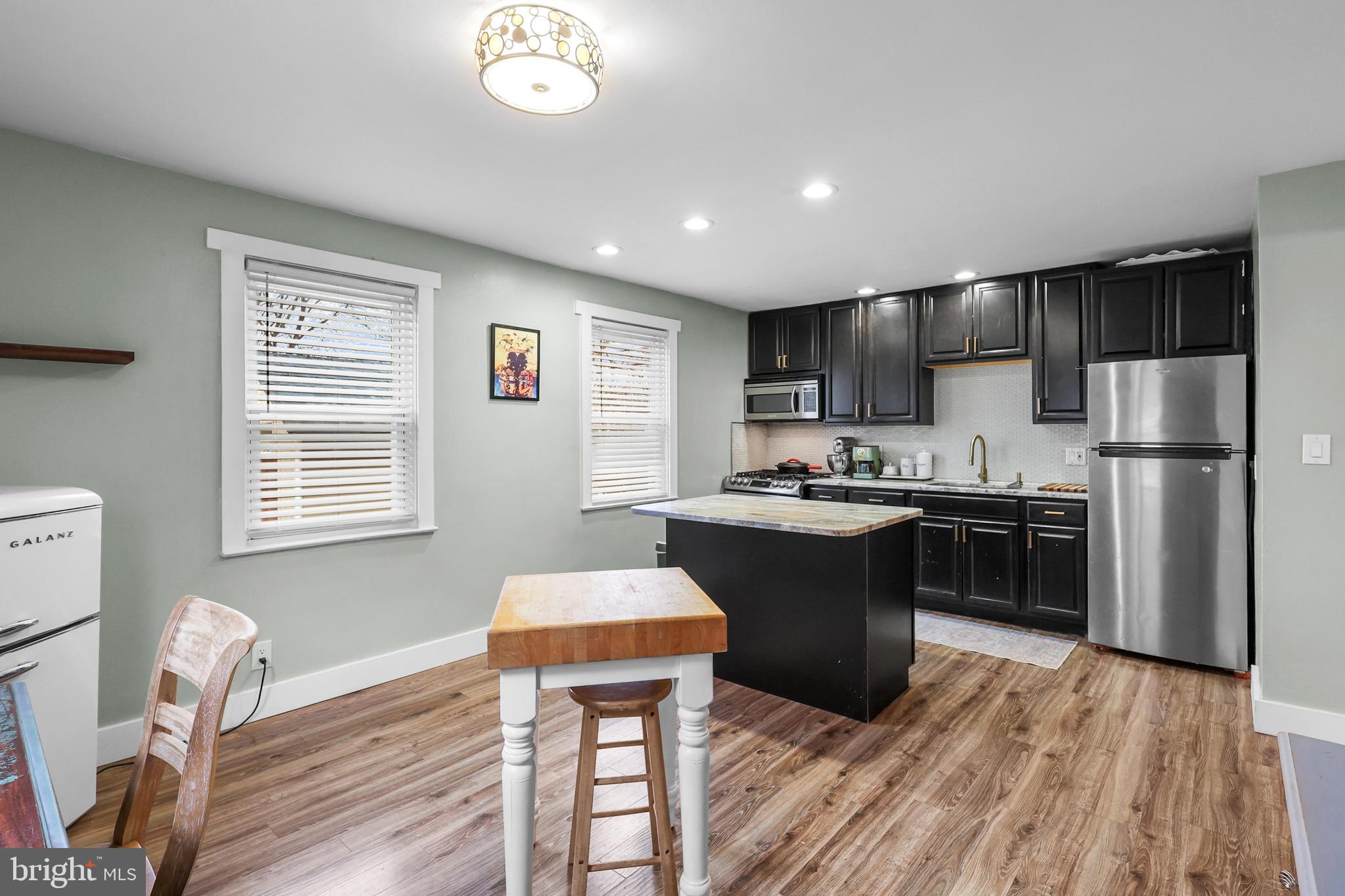 1020 Dartmouth Road Baltimore, MD 21212 - Photo 20 of 46 a kitchen with stainless steel appliances granite countertop a refrigerator a sink dishwasher a stove with wooden cabinets and wooden floor