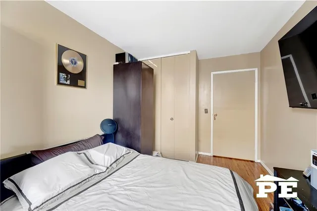 a bed sitting in a bedroom next to a window with a bookshelf