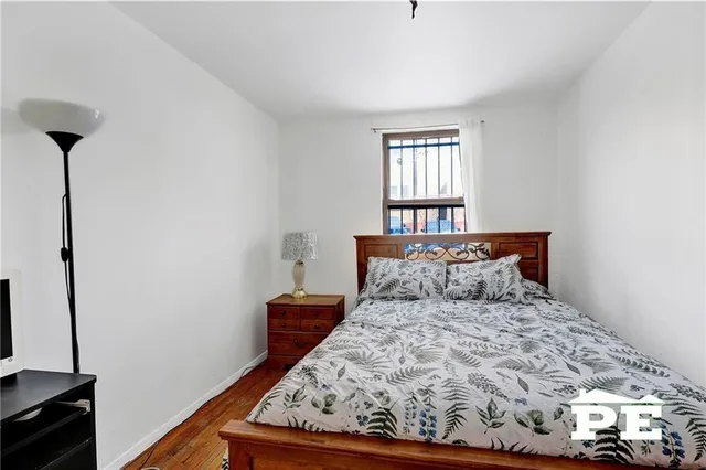 a bedroom with a bed and a tv on a dresser