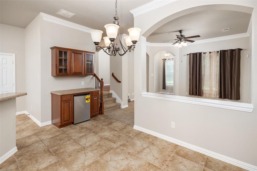 4245 Swan Forest Drive, Unit B Carrollton, TX 75010 - Photo 8 of 26 Kitchen featuring arched walkways, brown cabinets, ceiling fan, ornamental molding, and glass insert cabinets