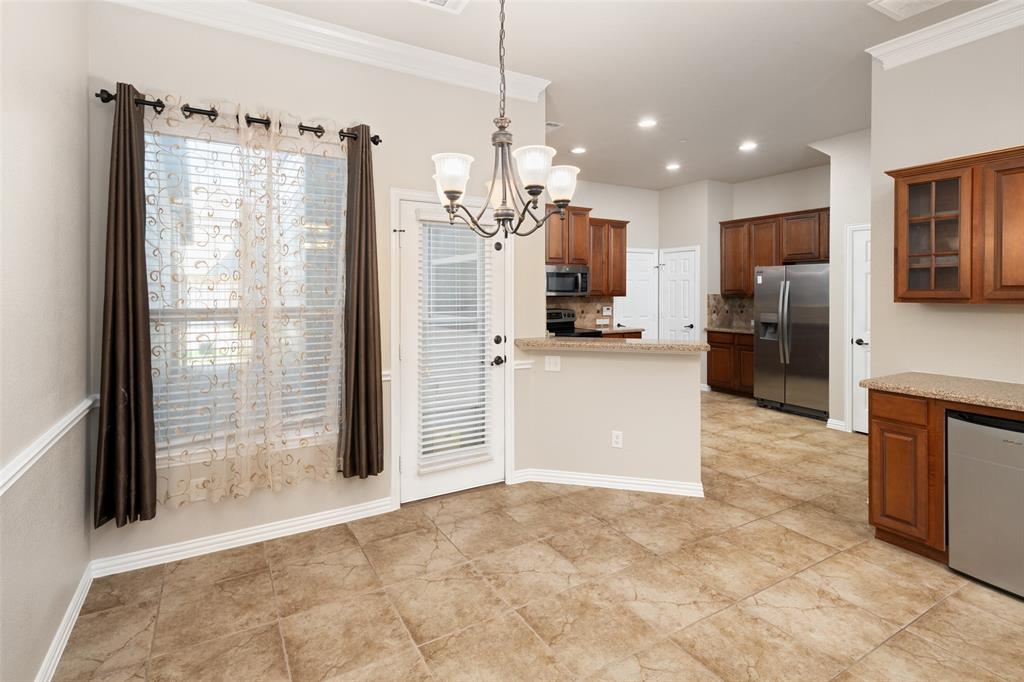 4245 Swan Forest Drive, Unit B Carrollton, TX 75010 - Photo 9 of 26 Kitchen with appliances with stainless steel finishes, a chandelier, decorative backsplash, ornamental molding, and a peninsula