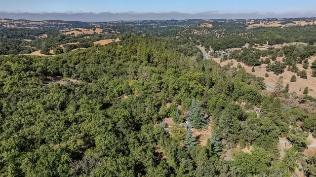 an aerial view of a houses with a lush green hillside