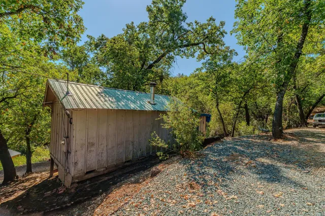 a view of a small house with wooden fence