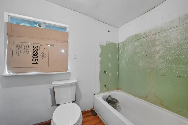 a white toilet sitting next to a bathroom sink and tub