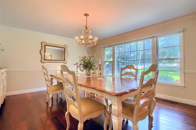 a dining room with furniture a chandelier and wooden floor