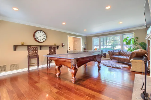 a living room with furniture a window and wooden floor