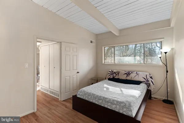 a bedroom with a bed and wooden floor