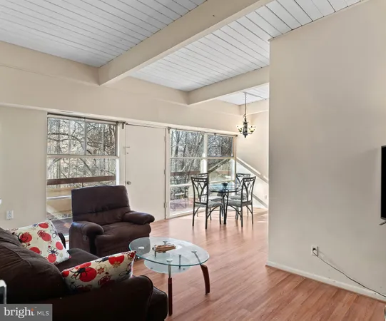 a living room with furniture and a table with wooden floor
