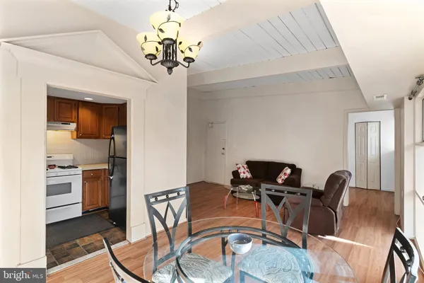 a view of a dining room with furniture a chandelier and wooden floor