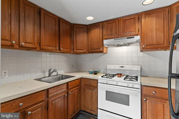 a kitchen with stainless steel appliances granite countertop wooden cabinets a stove a sink and dishwasher