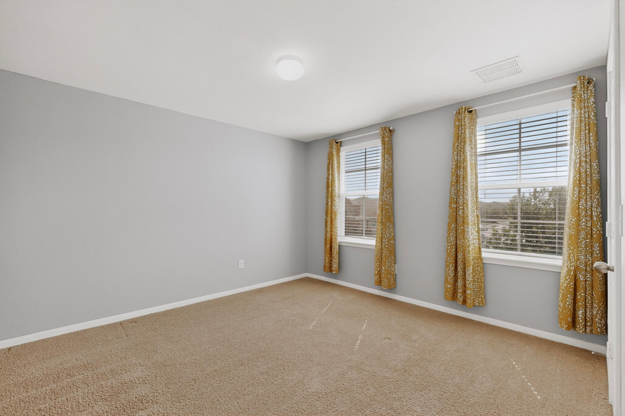 14513 Esker Road Manor, TX 78653 - Photo 22 of 38 A well-proportioned bedroom with ample natural light flowing through multiple windows, perfect for serene living.