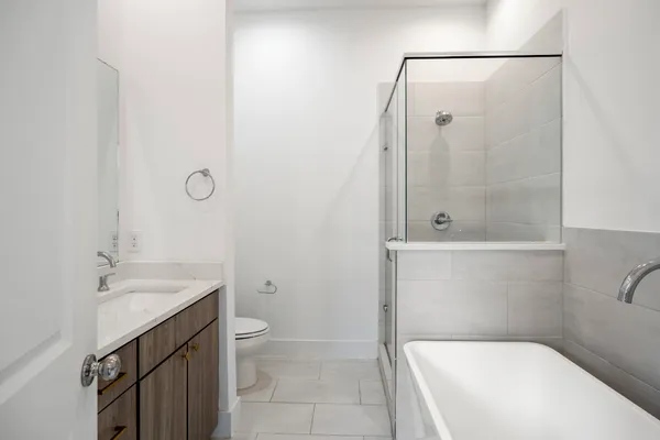 an empty room with wooden floor closet and windows