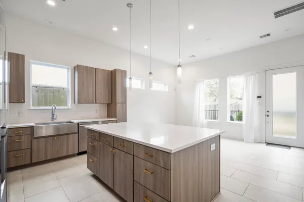 a kitchen with stainless steel appliances a sink a stove a refrigerator and cabinets