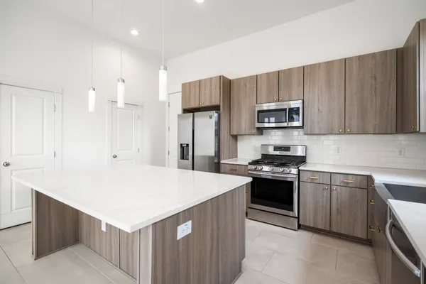 a large kitchen with a large counter top appliances and cabinets