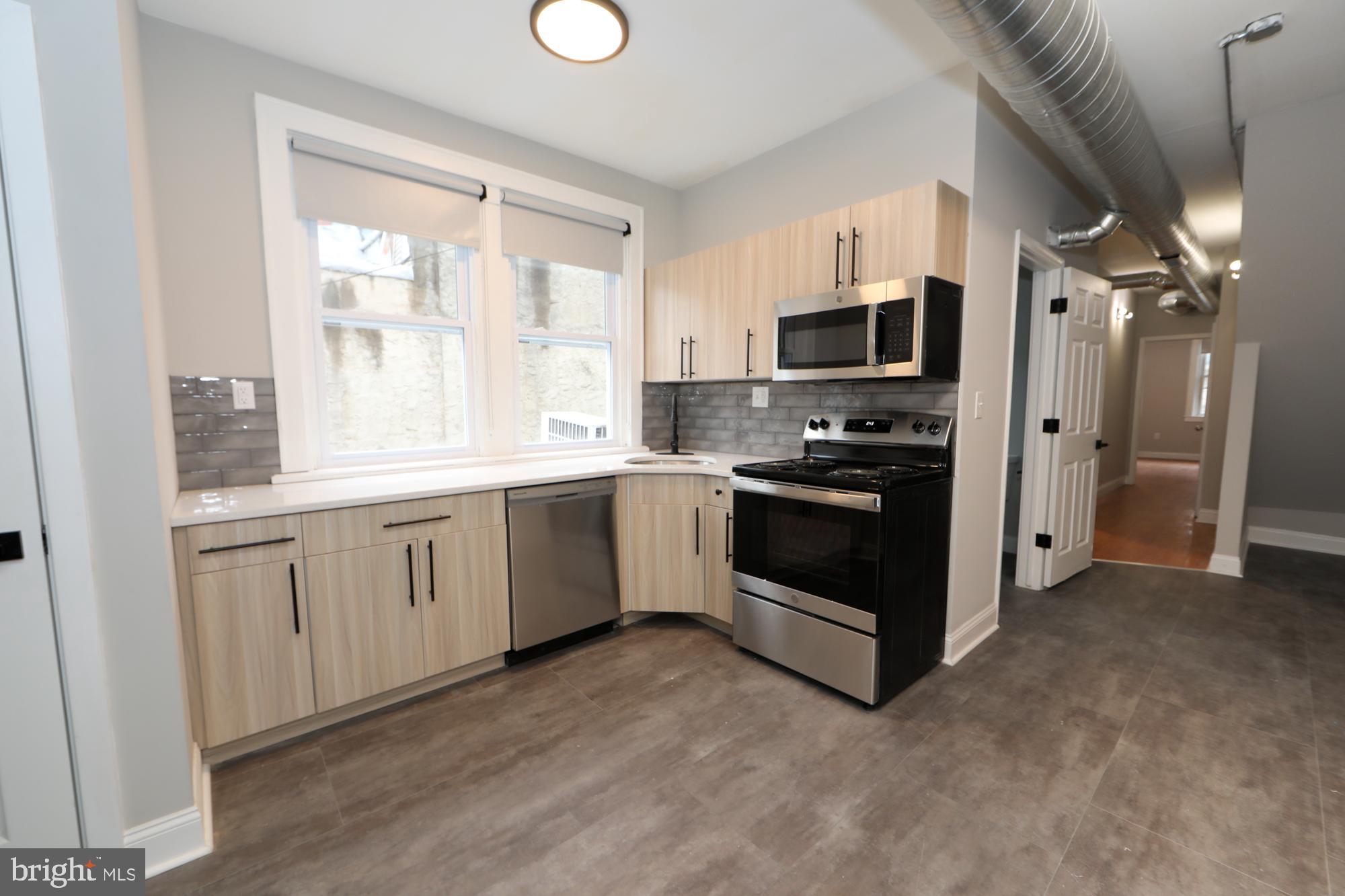931 Spring Garden Street, Unit 2 Philadelphia, PA 19123 - Photo 16 of 24 a kitchen with a sink stove and refrigerator