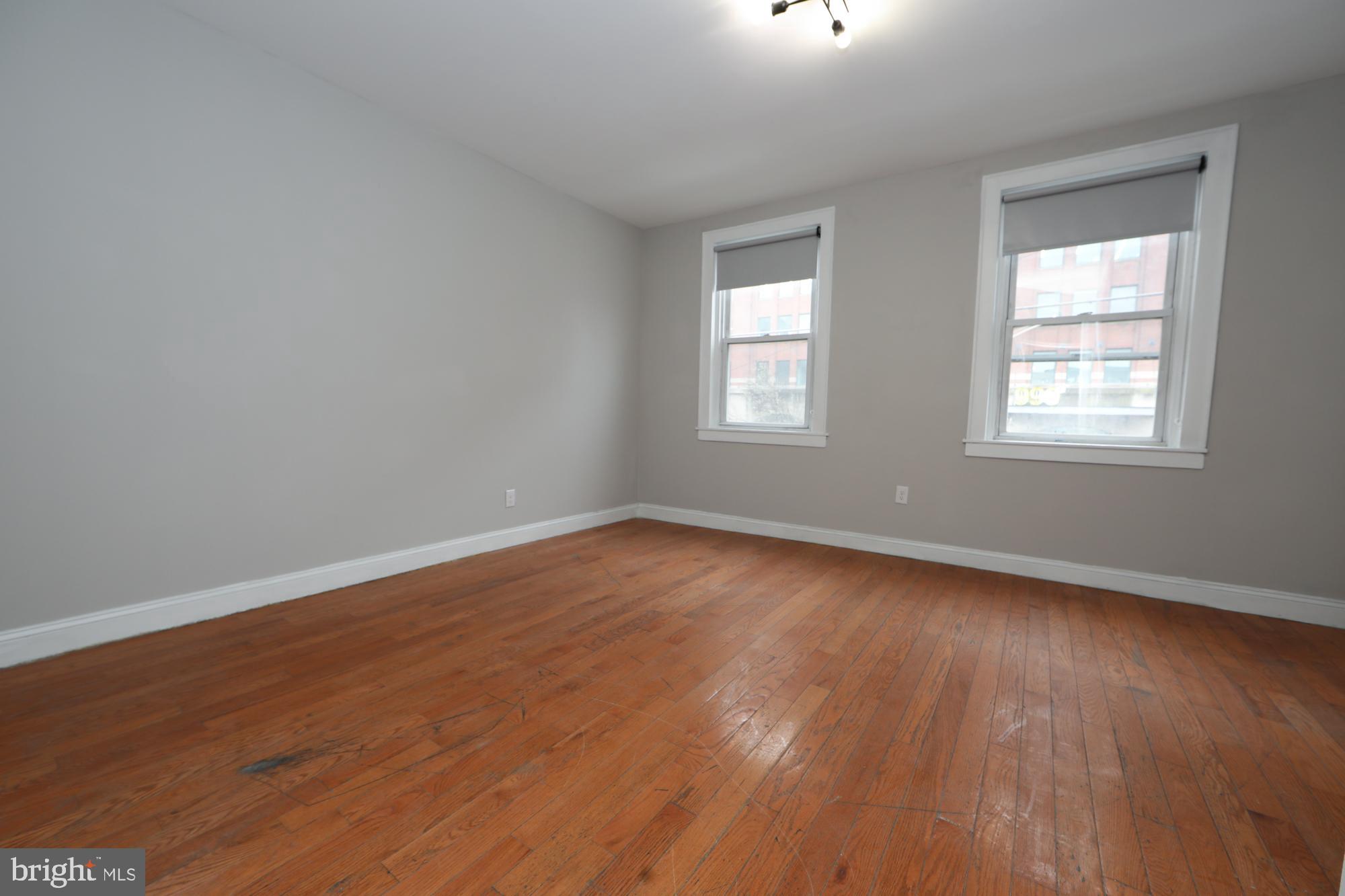 931 Spring Garden Street, Unit 2 Philadelphia, PA 19123 - Photo 5 of 24 an empty room with wooden floor and windows