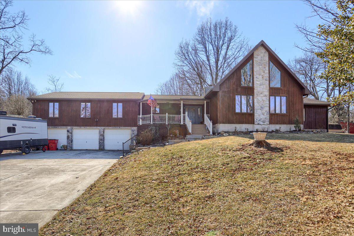 a front view of a house with a yard covered with snow and trees