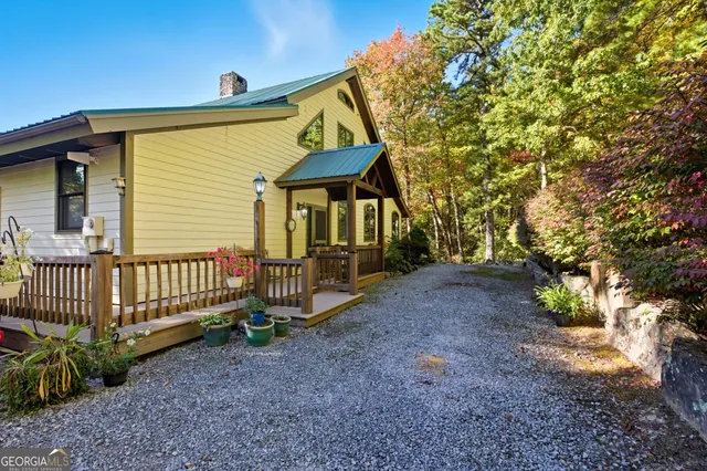 a view of a patio with table and chairs under an umbrella with a small yard
