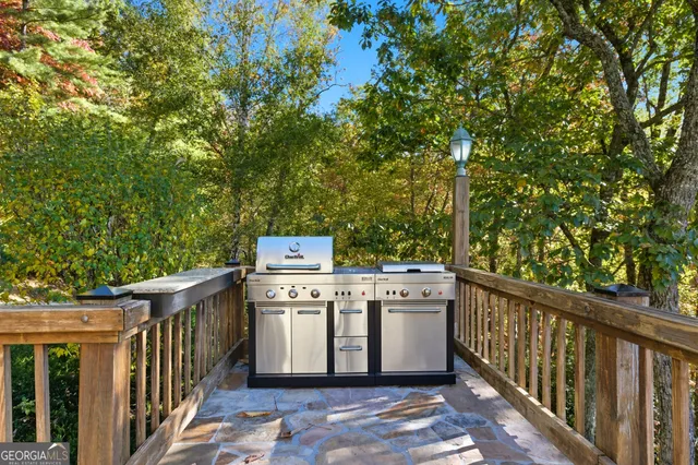 a view of a patio with chairs and table under an umbrella